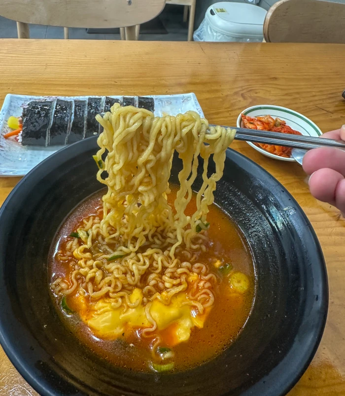 백마학원가 응달집 치즈라면 면을 젓가락으로 들어 올린 모습